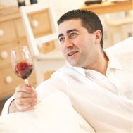 Image shows Vincent Gasnier holding a fine wine and smiling